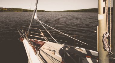 Yazın bir gölün kıyısındaki küçük bir teknenin önünde.