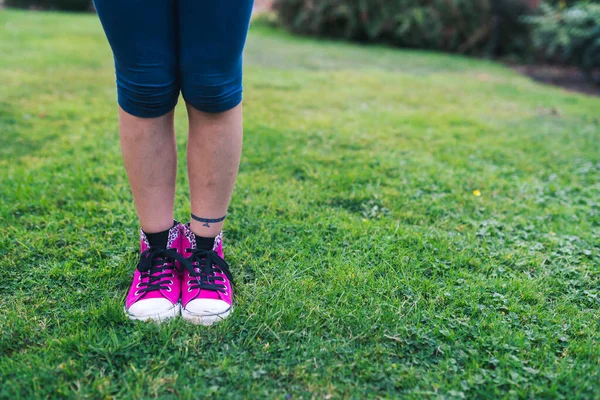 Ένα Κορίτσι Κομψό Ροζ Αθλητικά Παπούτσια Στέκεται Φρέσκο Πράσινο Γρασίδι — Φωτογραφία Αρχείου