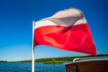 Polish flag fluttering on a boat on Jezioro Ostrowieckie in Poland