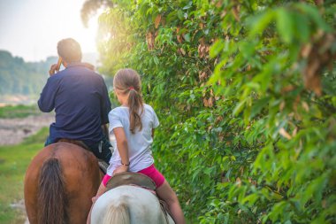 Çin kırsalında küçük bir midilliye binen sevimli beyaz kız.