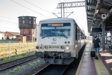 Bydgoszcz, Polonya - Ağustos 2020: Korumacı yüz maskesi takan orta yaşlı erkek adam, boş bir platformda tek başına duruyor planlanan trenin gelmesini bekliyor, covid19 salgını sırasında seyahat ediyor.