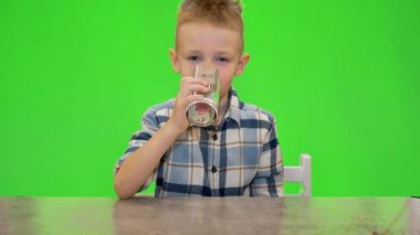 5 yaşında bir çocuk bardaktan su içiyor, kroma anahtarlı.