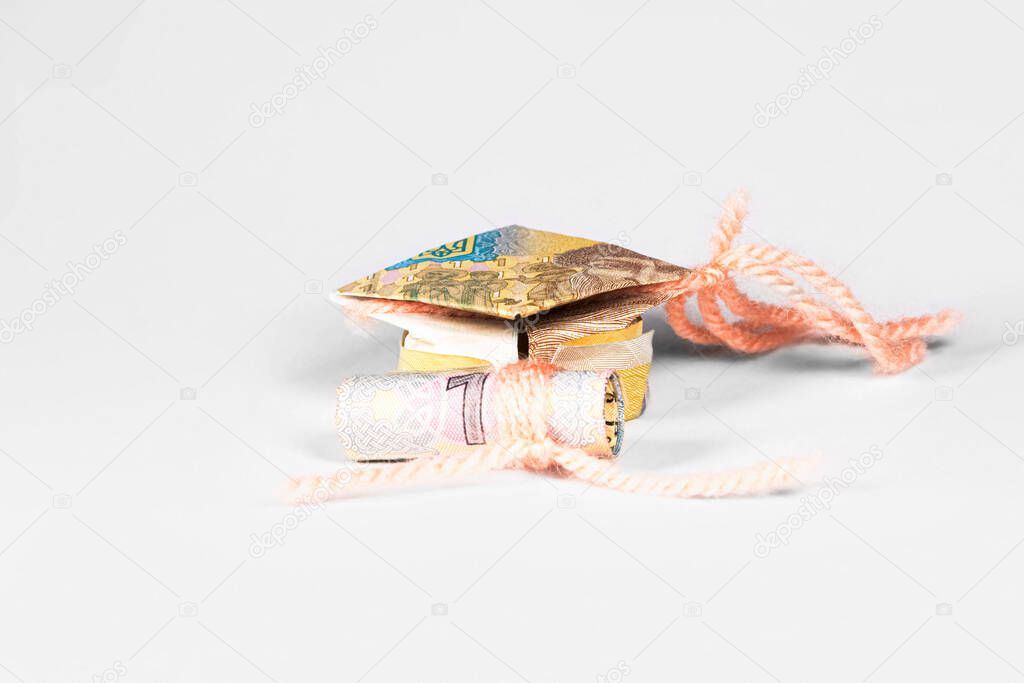 student cap and diploma made from a paper bill of the Ukrainian hryvnia