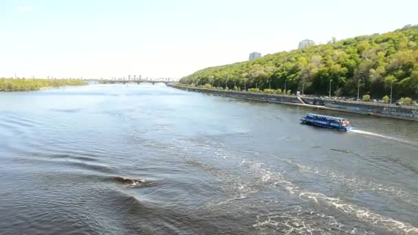 Un barco turístico navega a lo largo del río Dniéper en dirección a la Lavra de Pechersk y la estatua de la Patria. vista de la ciudad de Kiev — Vídeos de Stock