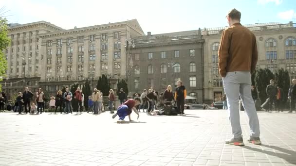 Kiev, Ukraine - April 24, 2021: guy with dreadlocks doing bottom break dance to music on the street — Stock Video