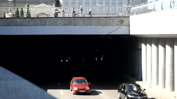 Kiev, Ukraina - 24 april 2021: bilar kör ut ur tunneln. På övervåningen finns en gågata för turister — Stockvideo