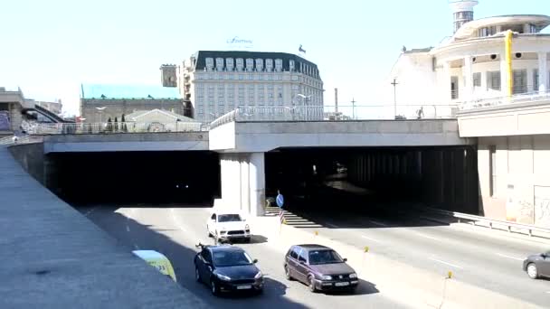 Kiew, Ukraine - 24. April 2021: Autos verlassen den Tunnel und fahren hinein. Im Obergeschoss gibt es eine Fußgängerzone für Touristen. Postgebiet — Stockvideo