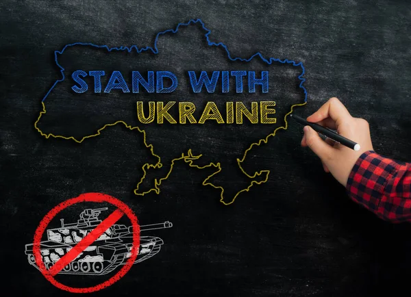 Meisje tekent een kaart van Oekraïne met de tekst Stand with Ukraine on the blackboard — Stockfoto