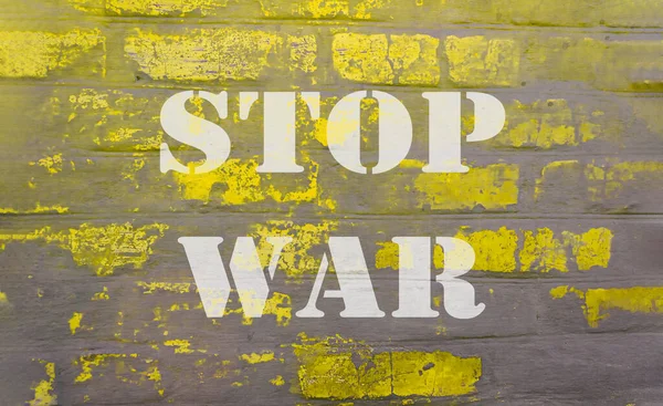 Texto sobre la pared de ladrillo gris amarillo detener la guerra — Foto de Stock