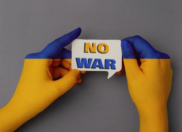 De meisjes handen zijn geschilderd in de kleur van de vlag van Oekraïne en houden een toespraak zeepbel met de tekst No War — Stockfoto