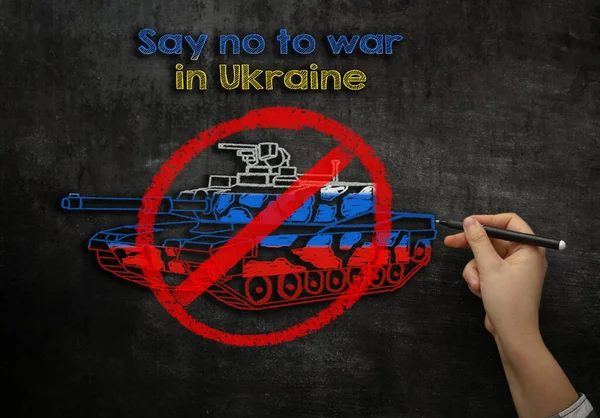 Дівчина малює танк на крейдяній дошці з текстом "Ні війнам в Україні". — стокове фото