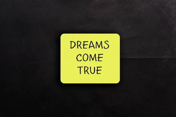Yellow Paper Card Words Dreams Come True Black Background Positive —  Fotos de Stock
