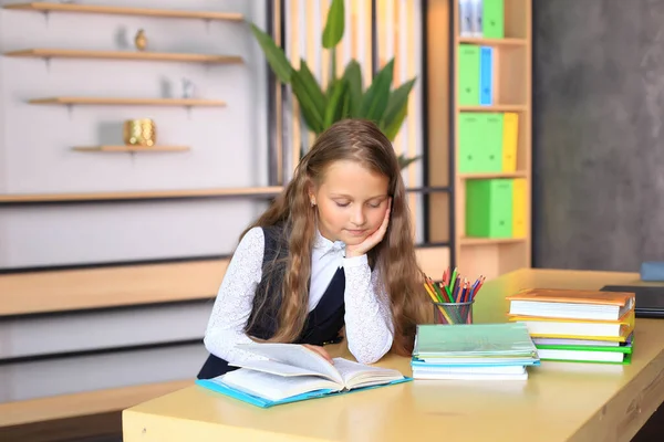 Die Schülerin sitzt über Notizbüchern. Das Mädchen schreibt in ein Schulheft. — Stockfoto