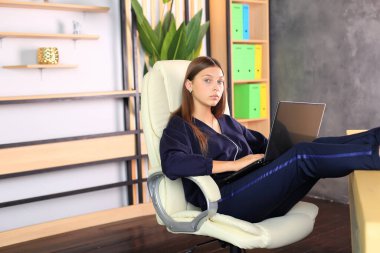 Ofisteki bilgisayarın başında genç bir kız oturuyor..