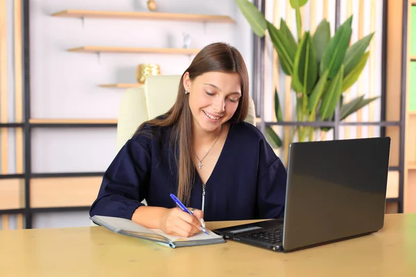 Uma jovem se senta em um computador no escritório. Imagens De Bancos De Imagens