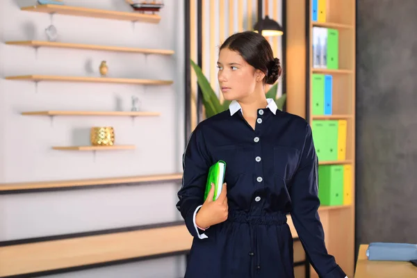 Retrato de uma menina de uniforme escolar com um livro nas mãos. Fotos De Bancos De Imagens Sem Royalties