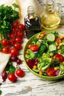 Kiraz domatesli taze salata, roka, salatalık, soğan ve nohut, zeytinyağı ve ahşap bir masada balzamik sosuyla birlikte..