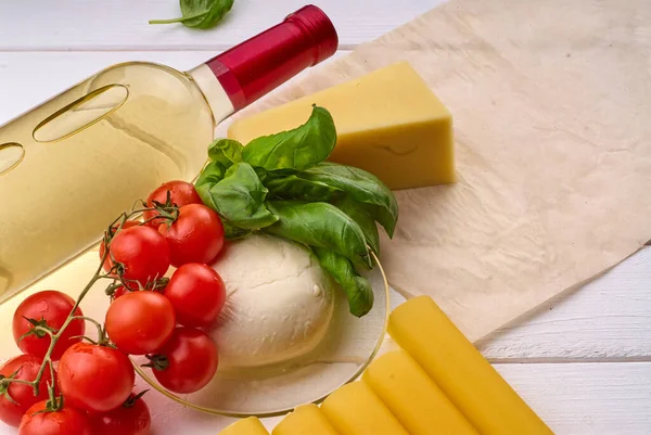 Bottiglia Con Vino Pomodorini Mozzarella Formaggio Cannelloni Tavolo Legno Bianco — Foto Stock