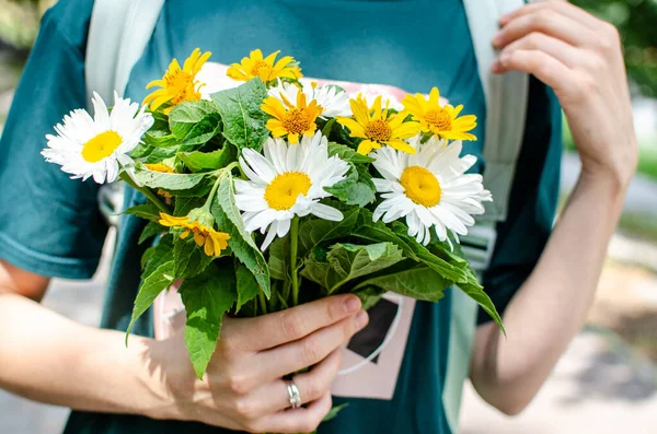 Evli bir kadının elinde bir buket yabani çiçek.