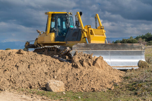 Excavator moving dirt and sand at a construction site