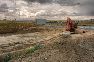 Kazıcı inşaat alanında bir yol inşa ediyor.