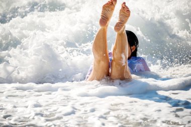 Dalgalardan ve denizdeki köpüklerden suya düşen kız..