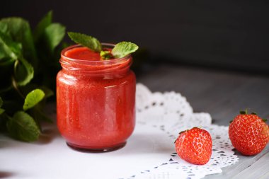 Çilekli smoothie çilek ve nane yaprakları koyu bir arka planda.