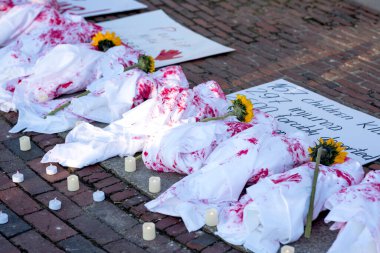 Kanlı bebekler, çiçekler ve mumlar. Ölü çocukların anısına Ukrayna 'yı desteklemek için kurulum