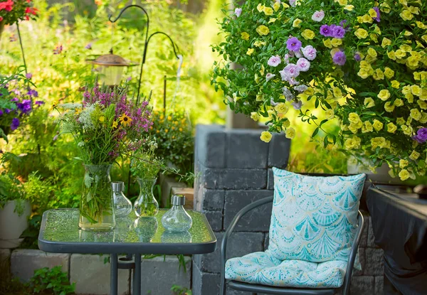 A bouquet of wild flowers on a table in the garden and cute lamps.