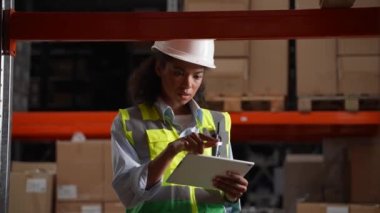 Depo çalışanı tabletten envanter çıkarıyor.