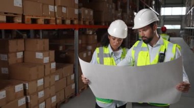 İki depo yöneticisi lojistik planını tartışıyor