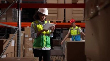 Stoklama sırasında tablet kullanan kadın denetleyici