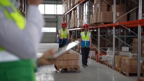 Warehouse worker using walkie-talkie and tablet — Stock Video