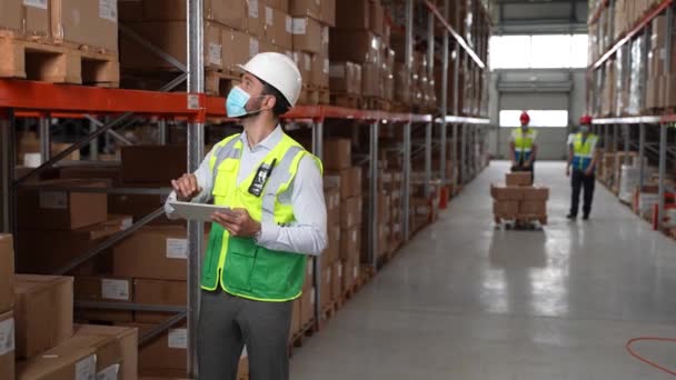 Inventaris manager doet inventarisatie in magazijn — Stockvideo