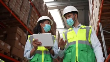 Stok sayımı sırasında maskeli depo çalışanları