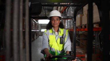 Forklift kullanan güzel bir kadın depo çalışanı.