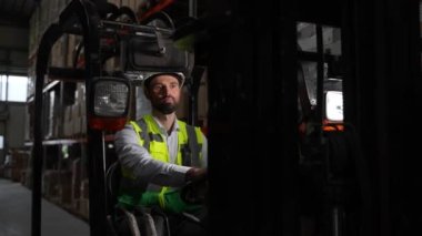 Depoda çalışırken sakallı forklift sürücüsü