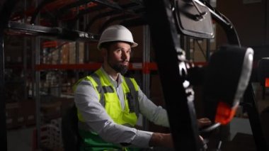 Forklift kullanan kendinden emin bir depo çalışanı.