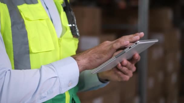 Mens magazijnmedewerker die tablet gebruikt tijdens inventarisatie — Stockvideo
