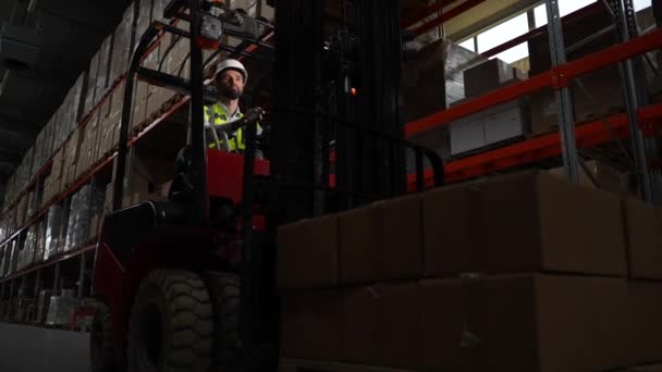 Trabajador de almacén en carretilla elevadora moviendo mercancías en cajas — Vídeos de Stock