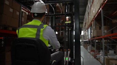 Depoda forklift kullanan erkek işçi.