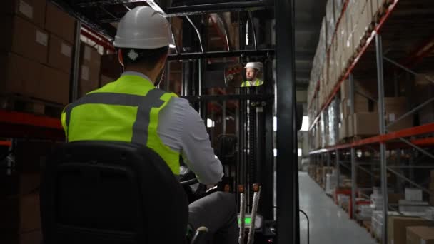 Mannelijke werknemer rijdt vorkheftruck rond magazijn — Stockvideo