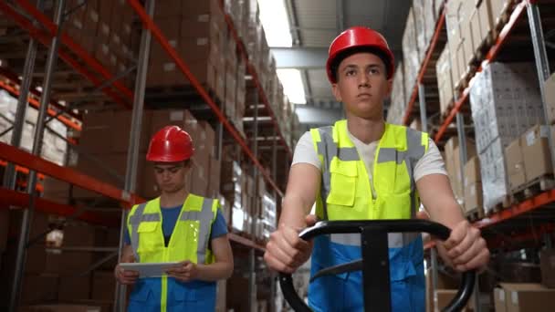 Jonge magazijnpersoneel loopt langs gangpad — Stockvideo