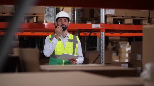 Engineer communicating by radio set in warehouse — Stock Video