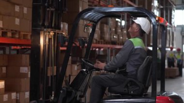 Depo işçisi forklift 'e yükleme yapıyor.