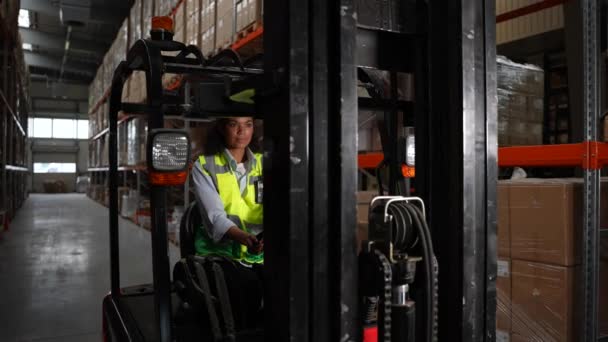 Vrouw vorkheftruckchauffeur rijdt rond magazijn — Stockvideo