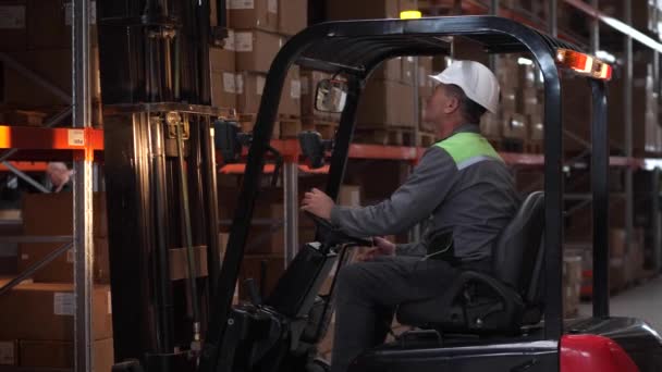 Male storehouse employee operating forklift truck — Stock Video