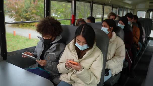 Adolescentes multiraciales en máscaras faciales montando autobús escolar — Vídeos de Stock