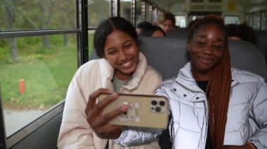 Okul otobüsünde selfie çeken güzel okul kızları.