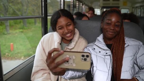 Jolies écolières posant pour selfie dans le bus scolaire — Video